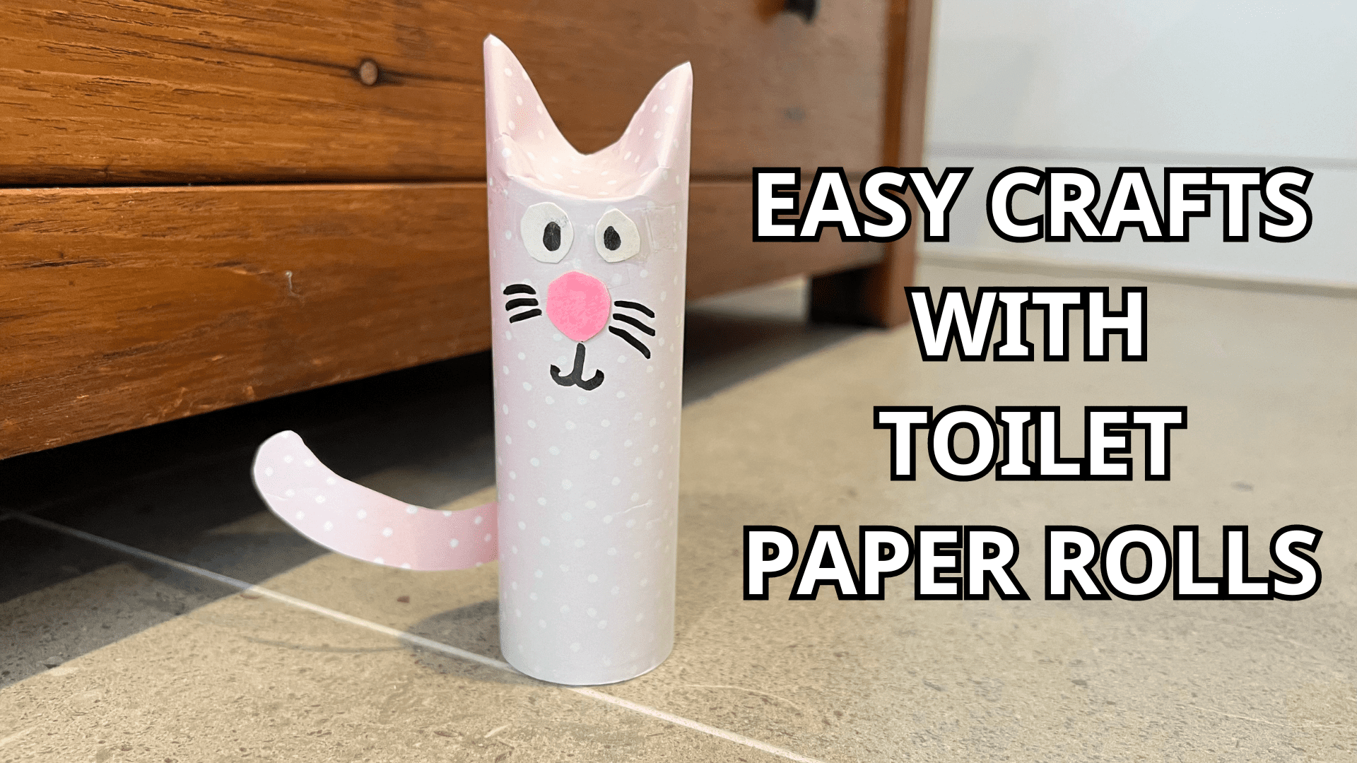 A photo of a smiling light pink kitty cat toilet paper roll. The text says "Easy Crafts with Toilet Paper Rolls". This introduces our easy crafts for kids with toilet paper rolls!